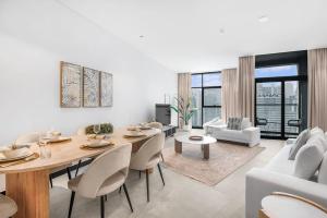 een woonkamer met een tafel en stoelen en een bank bij Meerak Homes - Glamorous 2 bed Apartment with Panoramic Views - Business Bay with free Wifi, Parking, Gym and Pool in Dubai