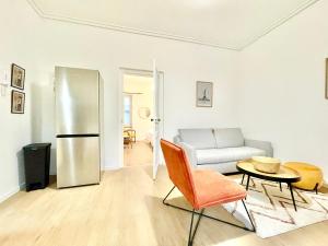 a living room with a refrigerator and a couch at Appartsaintnazaire - Saint Nazaire - 5 Appartements - Centre Ville in Saint-Nazaire