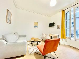 a living room with a couch and chairs and a table at Saint Nazaire - 2 Appartements - Centre Ville in Saint-Nazaire