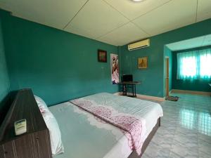 a bedroom with a bed and a green wall at Phet Ban Suan Hotel in Ko Chang