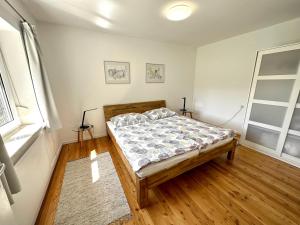 sypialnia z łóżkiem i drewnianą podłogą w obiekcie Haus im Grünen - Gmundennähe w mieście Pinsdorf
