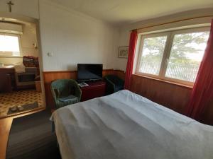 een slaapkamer met een bed, een bureau en een raam bij Házikó a Duna-parton in Ráckeve