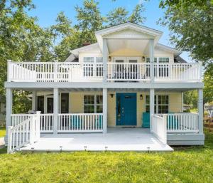 Una gran casa blanca con una puerta azul en Amazing Chesapeake Views Family getaway 4brms, en Chesapeake Beach