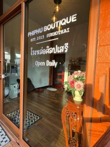 Phiphu Art and Gallery Boutique Sukhothai في سوخوثاي: نافذة متجر عليها لافتة