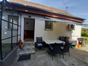a patio with a table and chairs in front of a house at Házikó a Duna-parton in Ráckeve