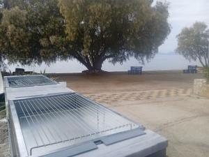 a view of a picnic table with a tree in the background at Vikos Beach Apartments in Paralía Iríon