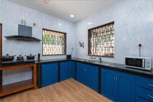 カラングートにあるVilla Calangute Phase 3の青いキャビネット、シンク、窓付きのキッチン