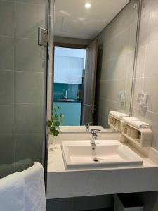 ein Bad mit einem Waschbecken und einem Spiegel in der Unterkunft Ecopark Happy Haven in HÆ°ng YÃªn