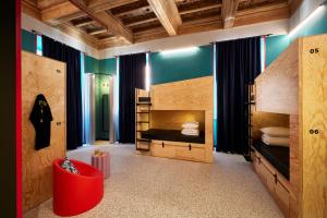 1 Schlafzimmer mit 2 Etagenbetten und einem roten Stuhl in der Unterkunft JO&JOE ROMA in Rom