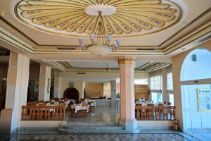 a dining hall with a chandelier and tables and chairs at Mahdia Palace Thalasso in Mahdia