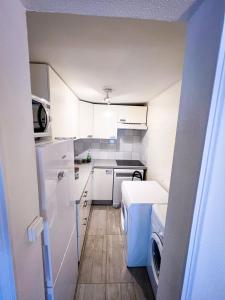 a small kitchen with white cabinets and a washer at Charming two-room apartment near Montparnasse in Paris