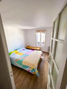 een kleine slaapkamer met een bed en een raam bij Charming two-room apartment near Montparnasse in Parijs