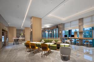 a lobby with tables and chairs and windows at Home2 Suites by Hilton Guiyang Guanshanhu in Guiyang