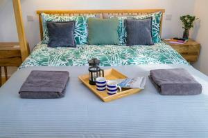 ein Bett mit zwei Handtüchern und zwei Tassen drauf in der Unterkunft Pilots Lodge by Deal Castle with free parking in Deal