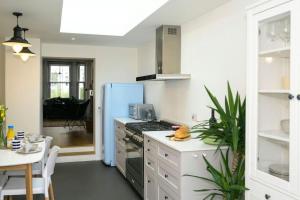 a kitchen with a refrigerator and a stove top oven at Pilots Lodge by Deal Castle with free parking in Deal