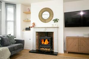 a living room with a fireplace and a tv at Pilots Lodge by Deal Castle with free parking in Deal