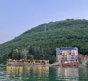 a building on the shore of a body of water at Hotel Cami in Debar