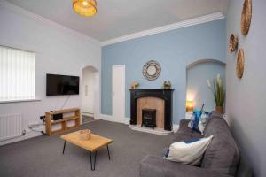 a living room with a couch and a fireplace at BayleafStay Seaham in Seaham