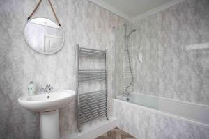 uma casa de banho com um lavatório, um chuveiro e um espelho. em BayleafStay Seaham em Seaham