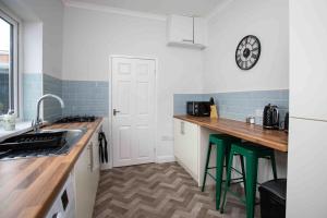uma cozinha com um balcão e um relógio na parede em BayleafStay Seaham em Seaham