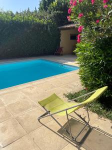 a green chair sitting next to a swimming pool at La Gandonne in Caderousse
