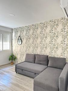 sala de estar con sofá frente a la pared en MALAGA INN APARTAMENTS, en Málaga