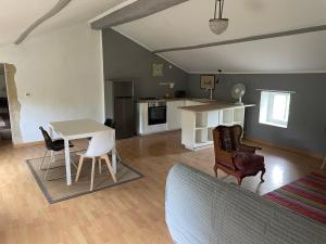 a kitchen and living room with a table and chairs at La Gandonne in Caderousse