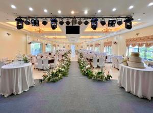 un salón de banquetes con mesas blancas y sillas blancas en Khách sạn Hoàng Sơn, en Sơn La