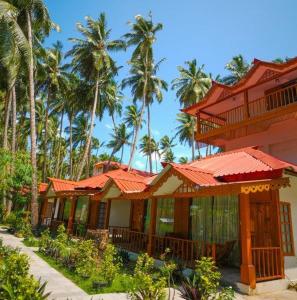 a building with red roofs and palm trees at Havelock Island Beach Resort in Havelock Island