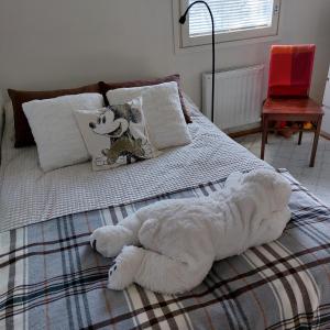 a white teddy bear laying on a bed at Blue River in Rovaniemi