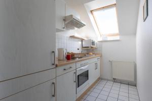 una piccola cucina con armadi bianchi e una finestra di LM3-33 - Ferienwohnung Typ AB Komfort a Schottwarden