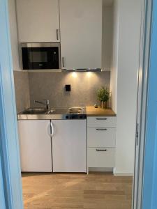 a kitchen with white cabinets and a sink at Studio Seaside in Tromsø