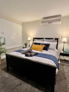 a bedroom with a large bed with yellow pillows at Cozy Urban Chinatown Escape Adelaide CBD - Free parking in Adelaide