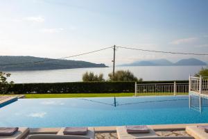 a swimming pool with a view of the water at Ionian Calm Villas in Vasiliki