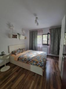 a bedroom with a bed and a table and a window at Thomas' place central -100m parc si metrou Tineretului in Bucharest