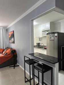 uma cozinha com uma mesa, um frigorífico e uma cama em Suites W-Riocentro no Rio de Janeiro