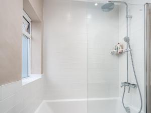 a white bathroom with a shower with a glass door at Pass the Keys Stunning 3 Bedroom Townhouse in Central St Albans in Saint Albans +18 photos