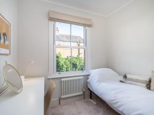a white room with a bed and a window at Pass the Keys Stunning 3 Bedroom Townhouse in Central St Albans in St. Albans
