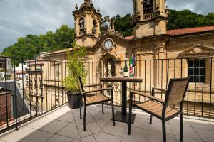 a balcony with a table and chairs in front of a building at Hotel Atari in Donostia-San Sebastián