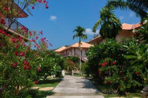 a walkway through a resort with flowers and palm trees at Blue Bay Resort in Ko Yao Yai