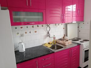 cocina con armarios rosas y fregadero en Karic apartman, en Paraćin