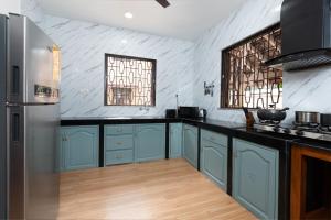 a kitchen with blue cabinets and a refrigerator at Villa Calangute Phase 4 in Calangute