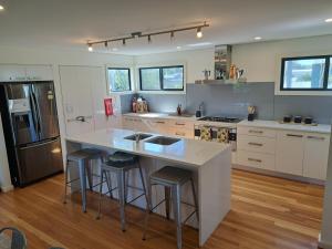 a kitchen with a large island with bar stools at Paradise by the Bay in Callala Bay