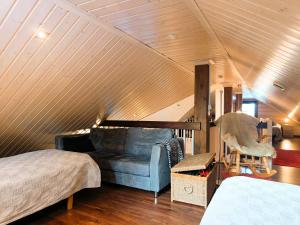 um quarto com um sofá e uma cadeira num sótão em Sinikko em Syöte