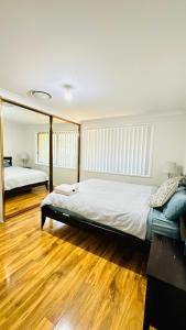 een slaapkamer met 2 bedden en een houten vloer bij Quiet family Townhouse in Wollongong CBD in Wollongong