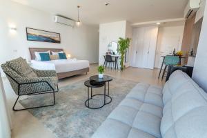 ein Wohnzimmer mit einem Sofa und einem Bett in der Unterkunft Hi-Yam SeaView Apartments & Suites - יש ממ"ד in Bat Yam