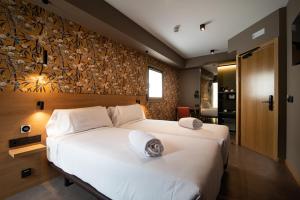 a bedroom with a large white bed in a room at Hotel Atari in Donostia-San Sebastián