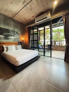 a bedroom with a large bed and a balcony at Yotaka The Hostel in Bangkok