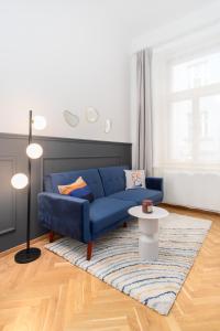 a living room with a blue couch and a rug at Lavish city center suites near National Theatre by Prague Days in Prague