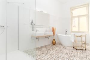 a white bathroom with a tub and a sink at Lavish city center suites near National Theatre by Prague Days in Prague